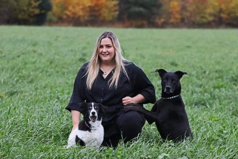 Katrin mit zwei Hunden in einer Wiese